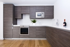 Custom-built kitchen with a sleek, modern design and big cabinets in light colors.