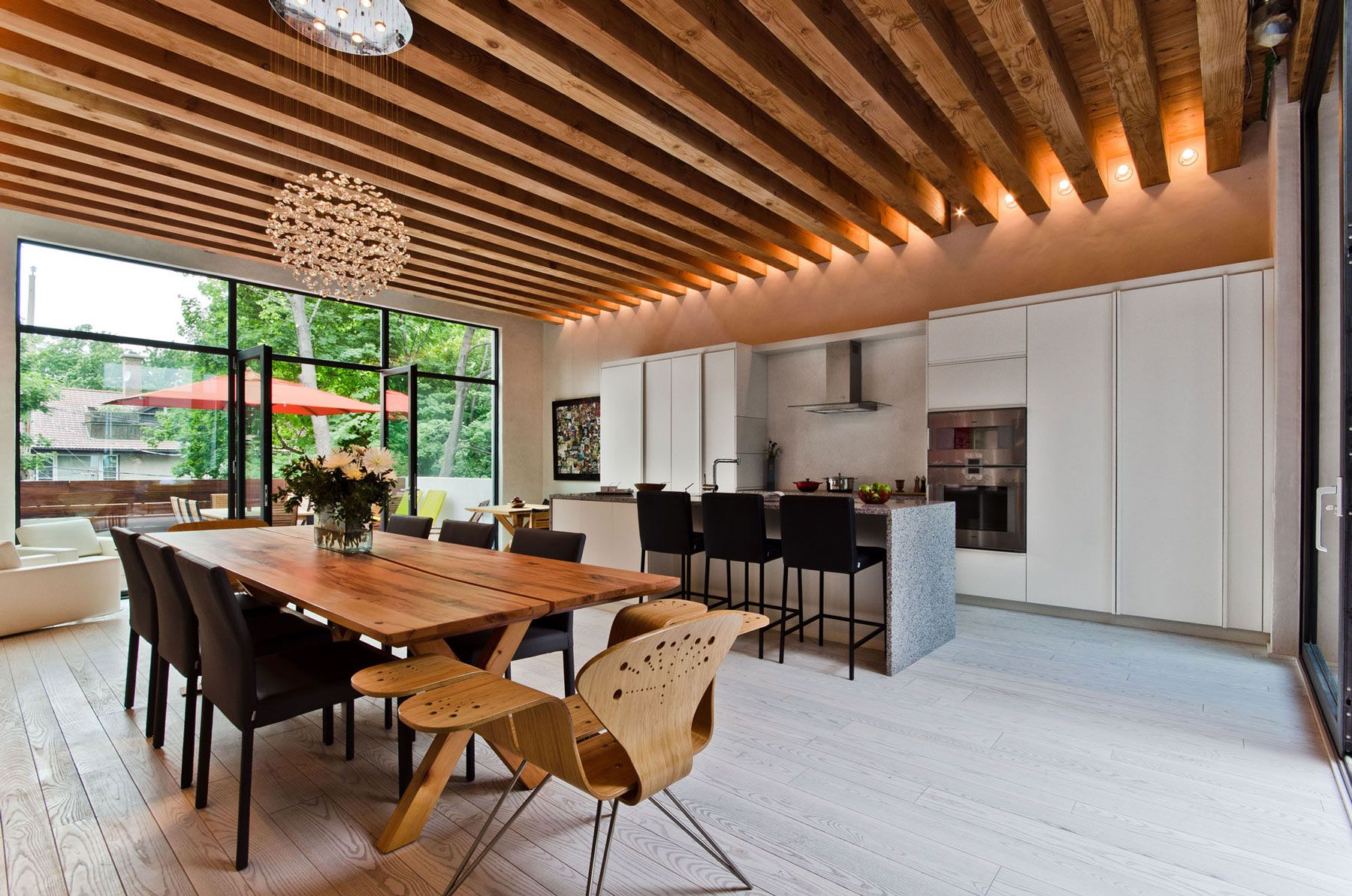 A modern large kitchen with a kitchen island and wooden ceiling