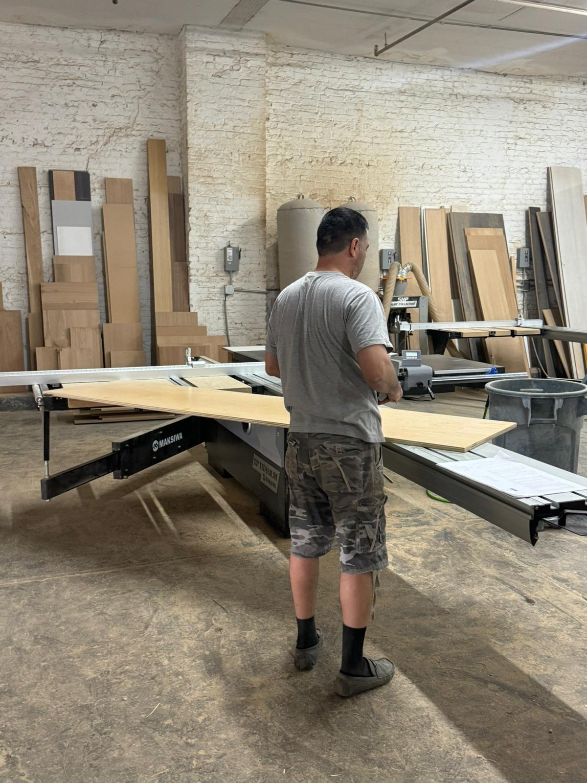 A woodworker produces custom designed kitchen cabinets in a millwork shop